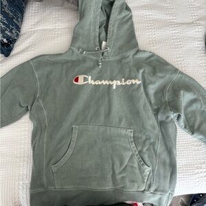 Champion green hoodie with a small champion logo on the sleeve